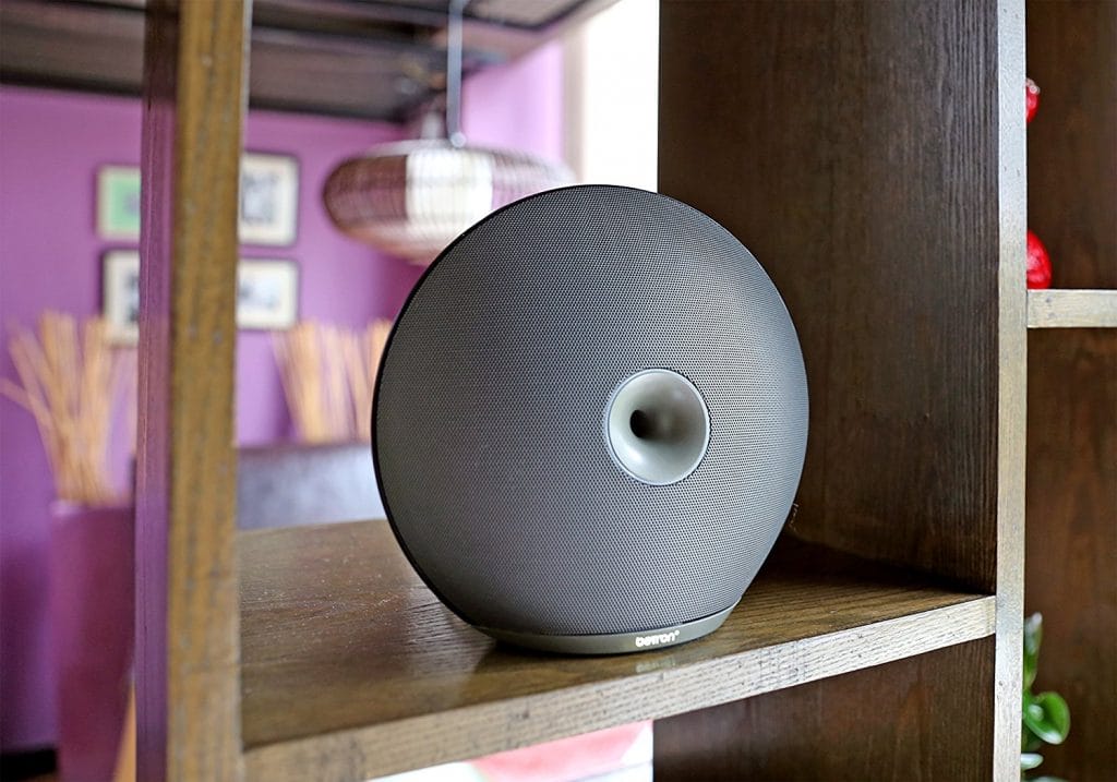 Image shows the speaker on a bookshelf. 