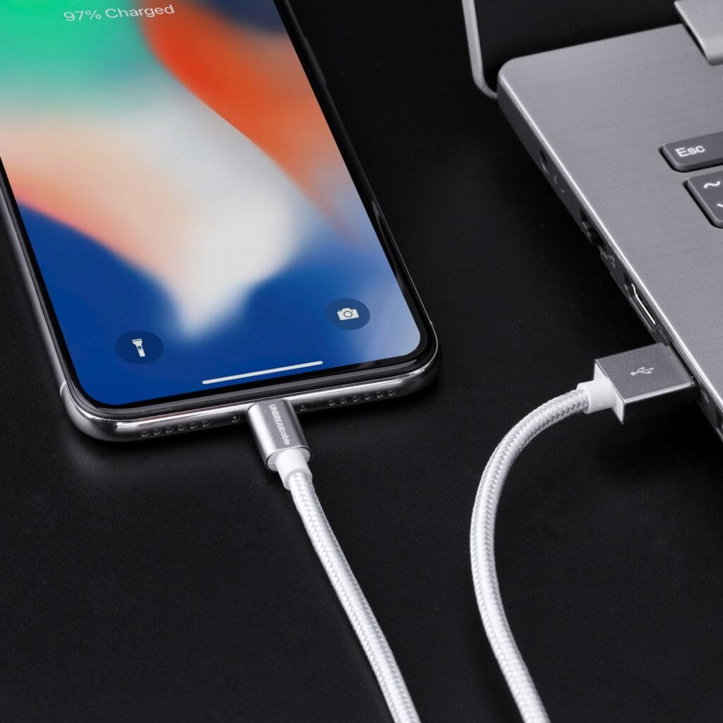 Image shows an iPhone being charged through a laptop.