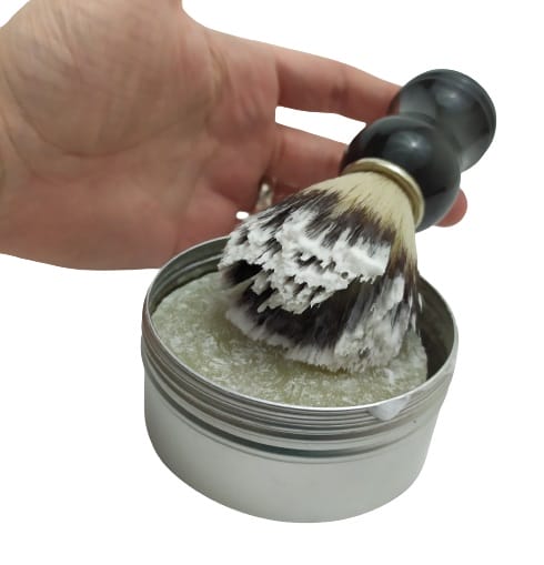 Image shows the shaving brush at an angle, it has been dipped into the Chapel Green Shaving Soap.