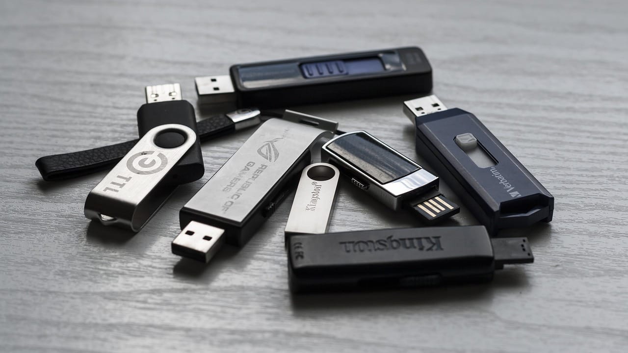 USB: Evolved from Chaos to Charge Image shows a bunch of USB memory sticks, or thumb drives.