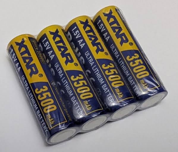 Four XTAR Ultra3500D AA lithium non-rechargeable batteries, each wrapped in clear plastic. The batteries are yellow with blue and white text, labeled "XTAR Ultra Lithium Battery," "1.5V AA," and "3500 mAh." They are arranged in a row on a plain, light grey surface.