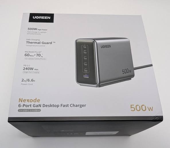 UGREEN Nexode 500W Charger A box for the UGREEN Nexode 500W Charger, featuring a sleek, rectangular charger with multiple ports (5 USB-C, 1 USB-A). The packaging highlights "500W High Power," "Fast Charge 5 Laptops Simultaneously," and "Thermal Guard™" technology. It also notes compatibility with a MacBook Pro 16", charging to 60% in 70 minutes, supports PD 3.1, delivers 240W maximum single-port charging, and includes a 2-metre 6.6-foot power cord. The design is modern with a grey finish.