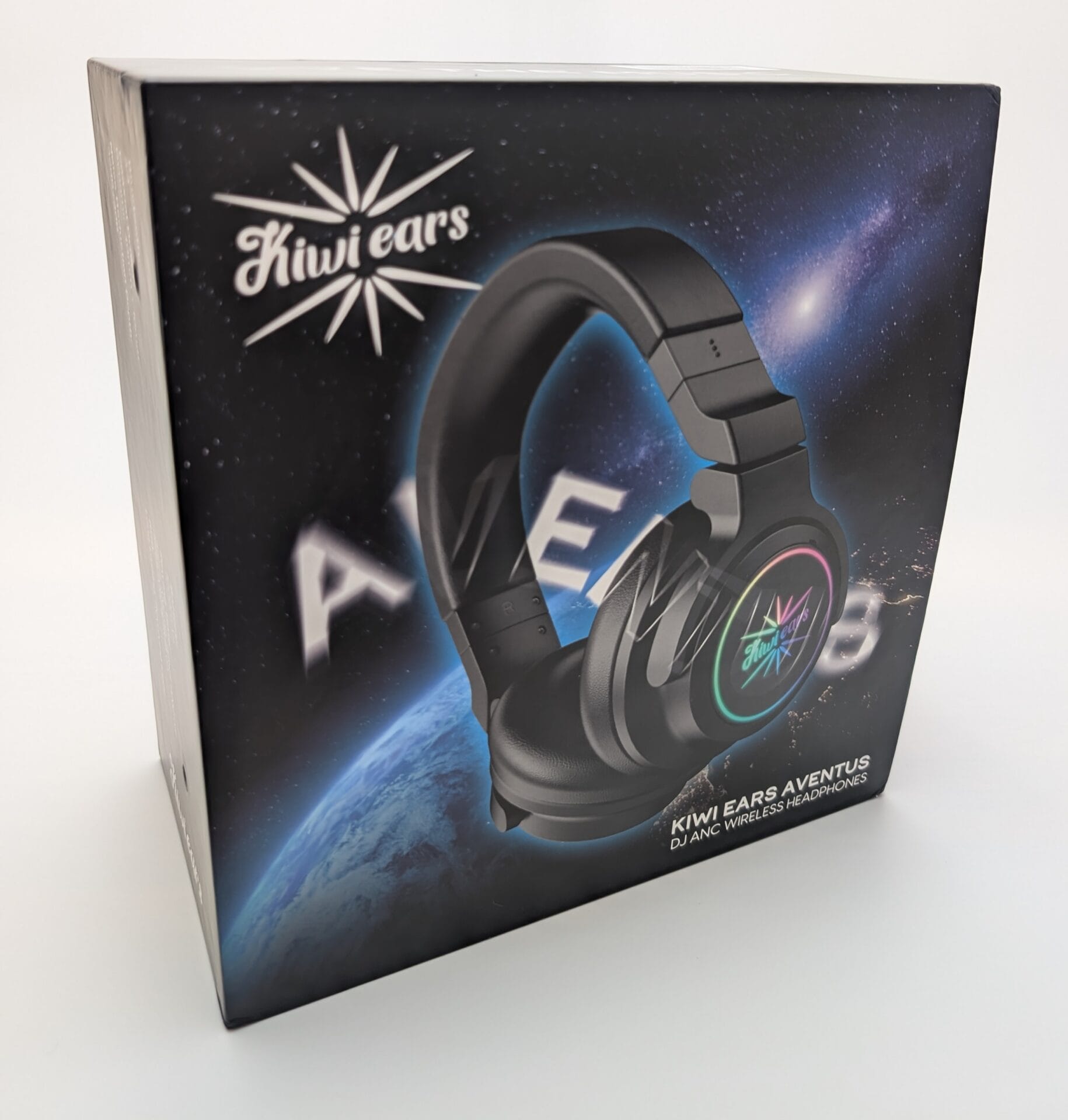Kiwi Ears Aventus A box featuring the Kiwi Ears Aventus DJ ANC wireless headphones, showcasing a sleek black over-ear design with vibrant RGB lighting on the ear cups. The packaging displays a cosmic background with Earth and stars, and the brand logo prominently in the upper left corner, with the model name "Aventus" highlighted in bold letters.