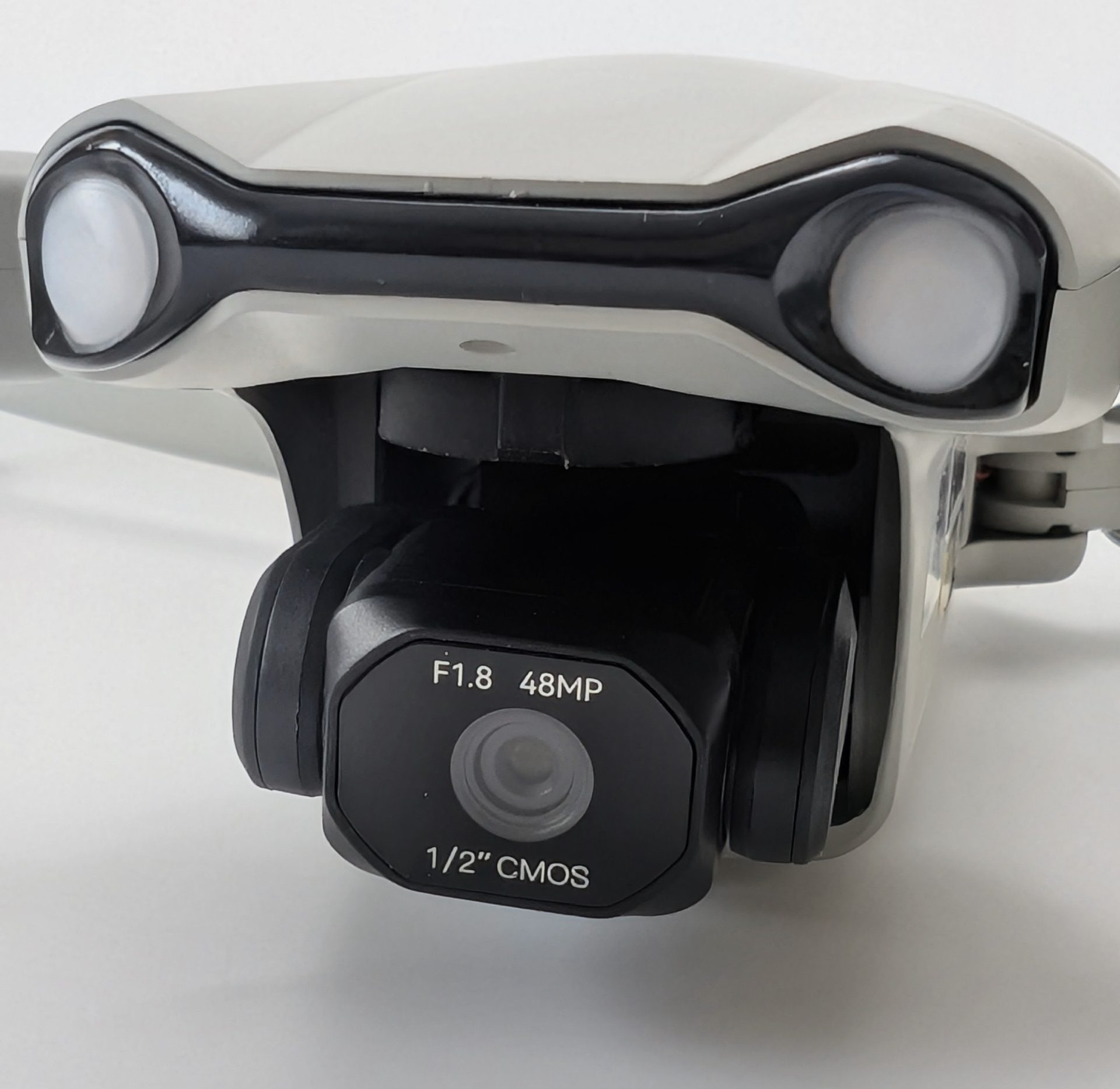 Close-up front view of the Ruko F11PRO 2 Plus drone, highlighting the 48MP camera gimbal with F1.8 aperture and 1/2-inch CMOS sensor, flanked by two bright white LED lights on the gray and black drone body.