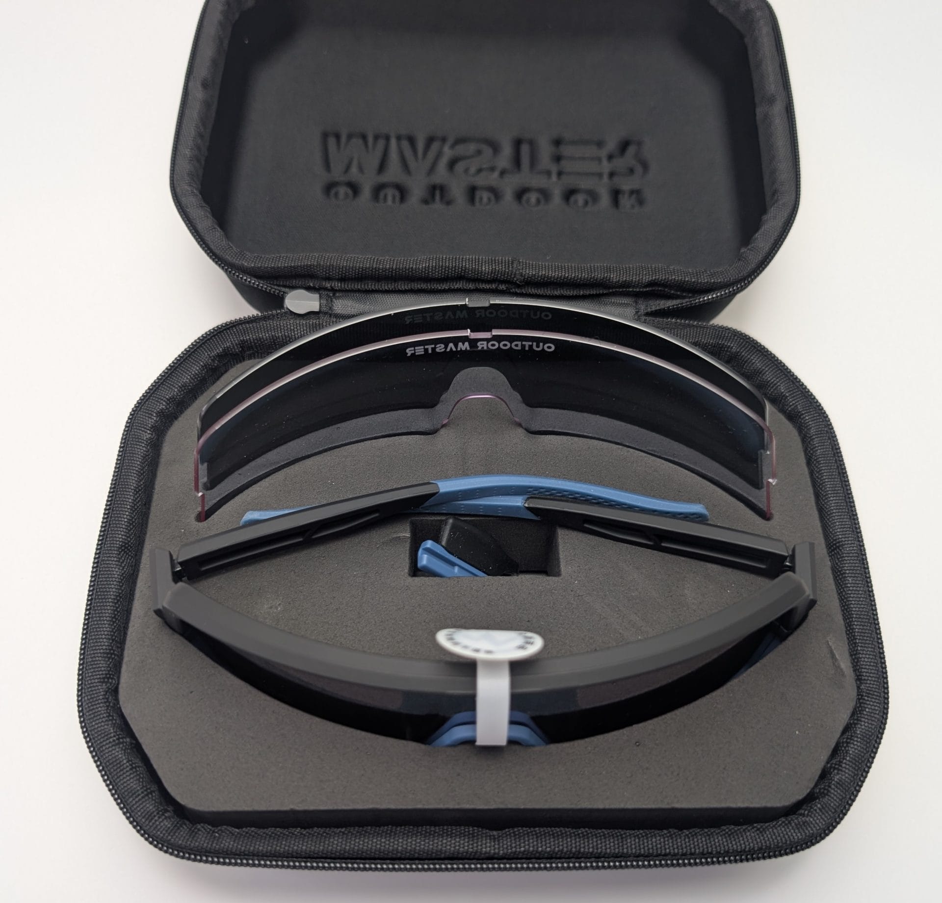 Outdoor Master Phoenix X Sports Sunglasses Black Outdoor Master Phoenix X performance sunglasses featuring a curved visor-style lens and blue rubberized details, displayed inside an open zippered carrying case.