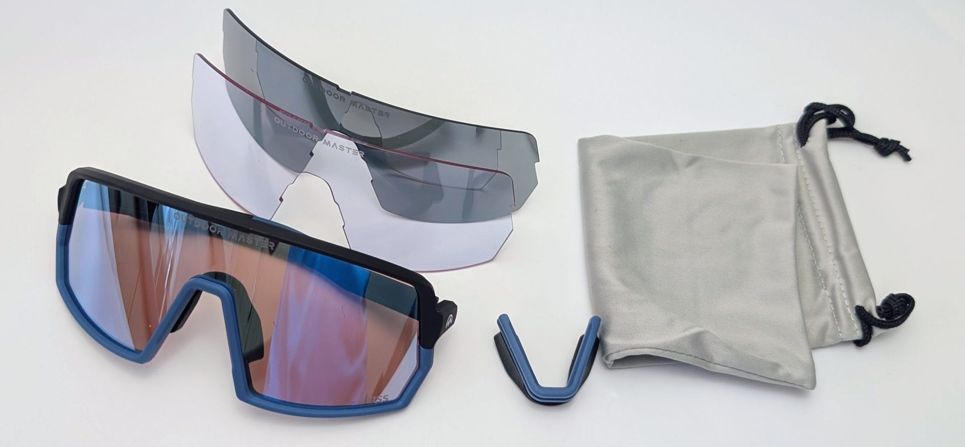 Outdoor Master Phoenix X Sports Sunglasses Outdoor Master Phoenix X sports sunglasses with blue and black frame and iridescent mirrored lens, shown with two interchangeable spare lenses (clear and smoke), a spare nose piece, and a grey microfiber storage pouch.