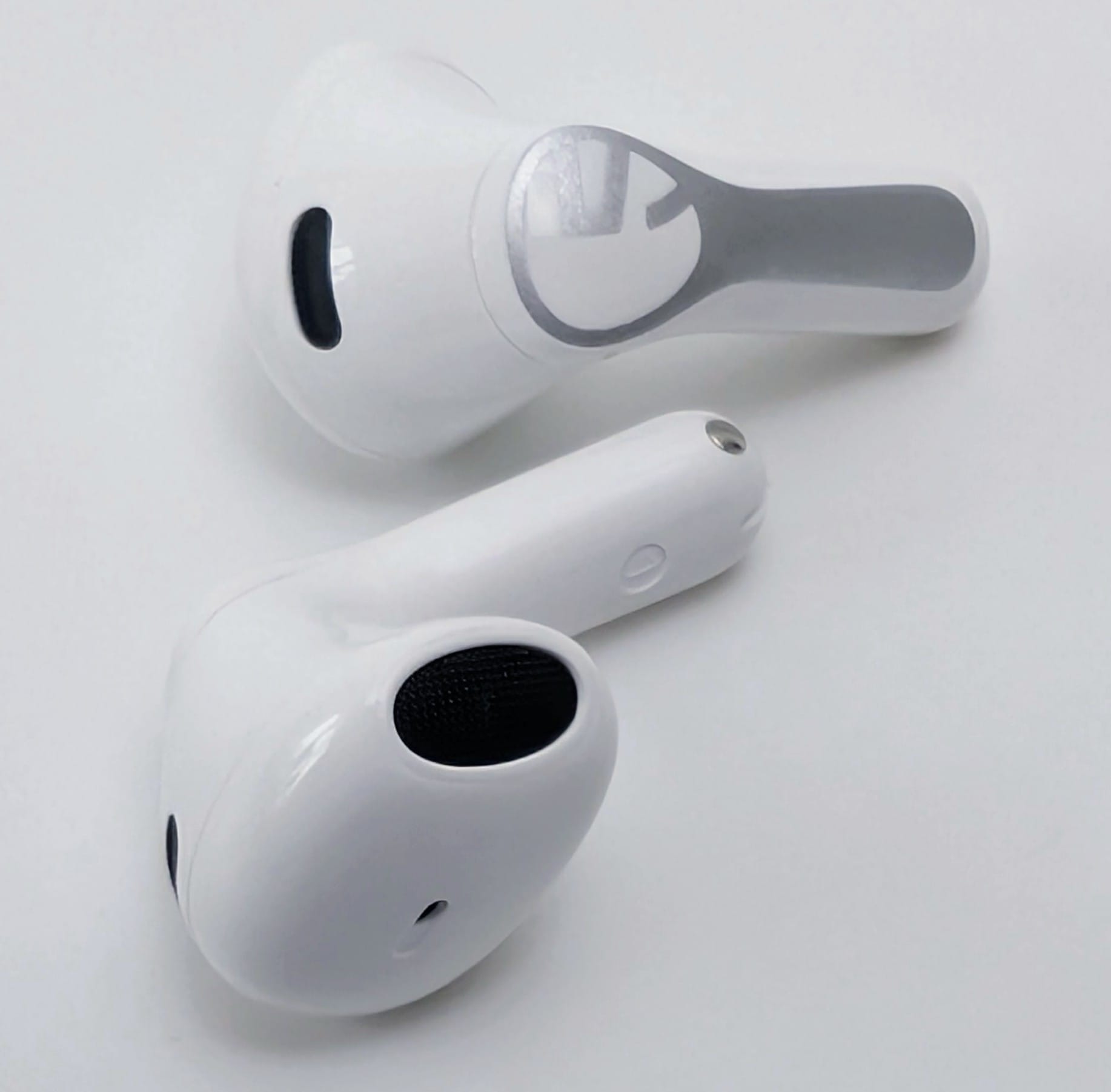 SoundPEATS Air6 HS Close-up of a pair of white SoundPEATS Air6 HS wireless earbuds on a plain white surface. One earbud shows the outer side with a silver shield logo on the stem; the other shows the inner side with the black mesh speaker grille, microphone hole, and charging contacts.